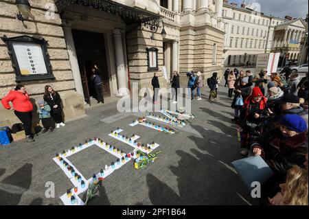 Lemberg, Ukraine, 16/03/2023, Menschen versammeln sich um Kerzenlicht in der Nähe des Opernhauses, um die Toten zu ehren. Die Russen feuerten einen Luftangriff auf das Theatergebäude in Mariupol ab, wo sich damals mehr als 1.000 Zivilisten befanden. Aufgrund dieser Tragödie starben viele Menschen, darunter auch Kinder. Um das Andenken an die Toten zu ehren und das Volk von Mariupol zu unterstützen, führen viele ukrainische Städte friedliche Aktionen unter dem Namen "WO SIND SIE?" durch. Russland marschierte am 24. Februar 2022 in die Ukraine ein und löste damit den größten militärischen Angriff in Europa seit dem Zweiten Weltkrieg aus Stockfoto