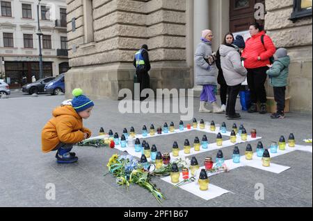 Lemberg, Ukraine, 16/03/2023, Menschen versammeln sich um Kerzen, die im Opernhaus angezündet werden, um die Toten zu ehren. Die Russen feuerten einen Luftangriff auf das Theatergebäude in Mariupol ab, wo sich damals mehr als 1.000 Zivilisten befanden. Aufgrund dieser Tragödie starben viele Menschen, darunter auch Kinder. Um das Andenken an die Toten zu ehren und das Volk von Mariupol zu unterstützen, führen viele ukrainische Städte friedliche Aktionen unter dem Namen "WO SIND SIE?" durch. Russland marschierte am 24. Februar 2022 in die Ukraine ein und löste damit den größten militärischen Angriff in Europa seit dem Zweiten Weltkrieg aus Stockfoto