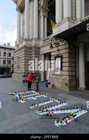 Lemberg, Ukraine, 16/03/2023, Menschen versammeln sich um Kerzen, die im Opernhaus angezündet werden, um die Toten zu ehren. Die Russen feuerten einen Luftangriff auf das Theatergebäude in Mariupol ab, wo sich damals mehr als 1.000 Zivilisten befanden. Aufgrund dieser Tragödie starben viele Menschen, darunter auch Kinder. Um das Andenken an die Toten zu ehren und das Volk von Mariupol zu unterstützen, führen viele ukrainische Städte friedliche Aktionen unter dem Namen "WO SIND SIE?" durch. Russland marschierte am 24. Februar 2022 in die Ukraine ein und löste damit den größten militärischen Angriff in Europa seit dem Zweiten Weltkrieg aus Stockfoto