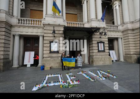 Die Menschen halten eine ukrainische Flagge im Opernhaus, da sie die Toten ehren. Die Russen feuerten einen Luftangriff auf das Theatergebäude in Mariupol ab, wo sich damals mehr als 1.000 Zivilisten befanden. Aufgrund dieser Tragödie starben viele Menschen, darunter auch Kinder. Um das Andenken an die Toten zu ehren und das Volk von Mariupol zu unterstützen, führen viele ukrainische Städte friedliche Aktionen unter dem Namen "WO SIND SIE?" durch. Russland marschierte am 24. Februar 2022 in die Ukraine ein und löste damit den größten militärischen Angriff in Europa seit dem Zweiten Weltkrieg aus (Foto: Mykola Tys/SOPA Images/Sipa USA) Stockfoto