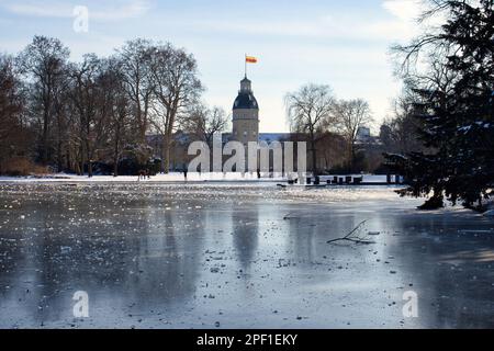 Karlsruhe - 12. Februar 2021: Karlsruhe-Palast hinter einem gefrorenen See an einem Wintertag in Deutschland. Stockfoto