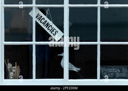 Ein "Wir haben freie Zimmer" -Schild hängt vor dem Fenster eines britischen Ferienhauses am Meer. Übernachtung mit Frühstück oder Kurzurlaub Let's Stockfoto