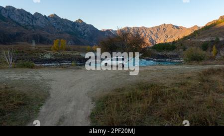 Ein altes Auto der Marke „Honda HR-V“ steht in der Ferne der Straße unter den Bergen in der Nähe des Flusses Katun in Altai in Sibirien. Altai, Russland - Stockfoto