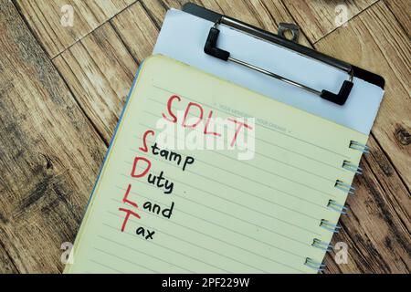 Konzept der SDLT - Stempelgebühr Grundsteuer auf Buch isoliert auf Holztisch schreiben. Stockfoto