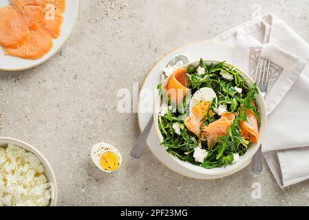 Löwenzahnsalat mit geräuchertem Lachs, Ei und frischem Käse aus nächster Nähe Stockfoto