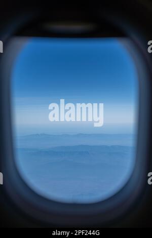 Blick auf die Berge. Hügel und weiße Wolke mit blauem Himmel am Morgen vom Flugzeugfenster. Stockfoto