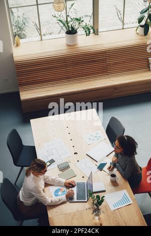Draufsicht von Büromitarbeitern, die während des Arbeitstages neue Projekte diskutieren Stockfoto