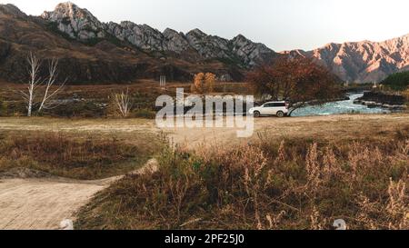 Ein altes Crossover-Auto der Marke „Honda HR-V“ steht an der Straße unter einem Baum in der Nähe der Berge in der Nähe des Flusses in Altai in Russland. Altai, Russland - Oktober Stockfoto