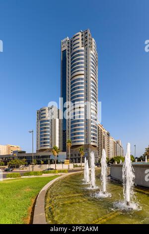 Ein hohes Gebäude mit Hotel und Büros mit gebogenen Fassaden aus Metall und Glas Stockfoto