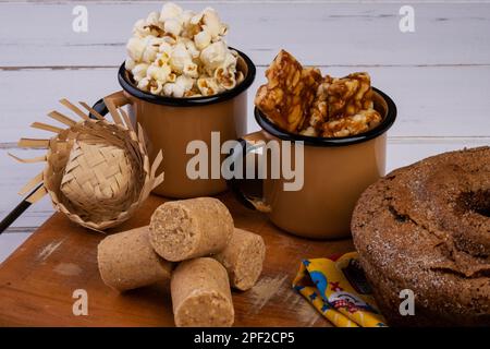 Holzteller mit Kuchen, Popcorn, Paecoquinha und pé de Moleque - Juni-Party. Stockfoto