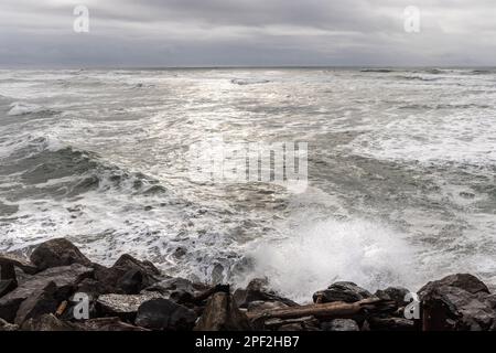 Sonnenschein auf dem Ozean mit Wellen auf den Felsen am Columbia River South Jetty Stockfoto