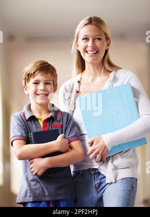 Ihre Lieblingsschülerin. Ein Lehrer und ein kleiner Junge gehen zusammen den Flur entlang. Stockfoto