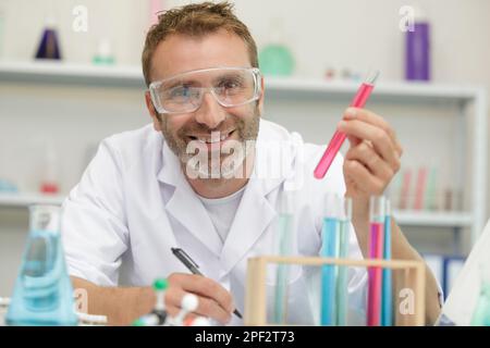 Porträt eines männlichen Wissenschaftlers, der ein Reagenzglas hält Stockfoto