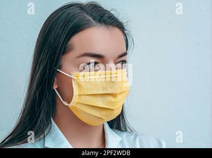 Porträt einer Arztfrau bei einer gelben Maske Coronavirus-Epidemie Stockfoto