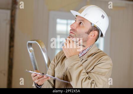 baumeister neben der Leiter Stockfoto