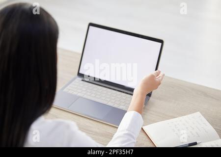 Oben steht, dass ein Manager aus unbekannten gemischten Rassen im Büro auf einem Laptop tippt. CEO sitzt allein und nutzt Technologie, Papierkram, um nach dem Bewerber zu suchen Stockfoto