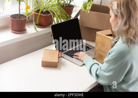 Nahaufnahme eines weiblichen Online-Shops, Inhaber eines kleinen Unternehmens, Unternehmer, der Verpackungspakete nach dem Versand vorbereiteter Versandkarton auf dem Tisch vorbereitet Stockfoto