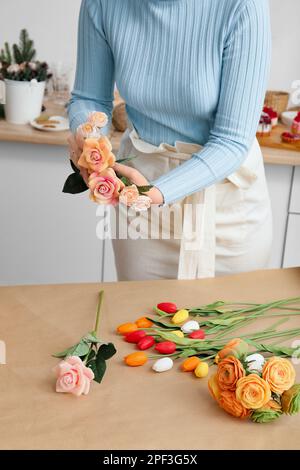 Die Blumenmeisterin macht einen Strauß. Seifenstrauß in den Händen eines Floristen. Rosen und Tulpen in den Händen eines Mädchens. Stockfoto