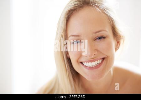 Ihr Lächeln kann jeden Raum erhellen. Nahaufnahme einer schönen jungen Frau, die dich mit einem fröhlichen Lächeln ansieht. Stockfoto