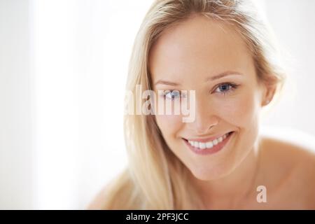 Wohlbefinden und gutes Aussehen - Wohlbefinden und Wellness. Nahaufnahme einer schönen jungen Frau, die dich mit einem Lächeln ansieht. Stockfoto