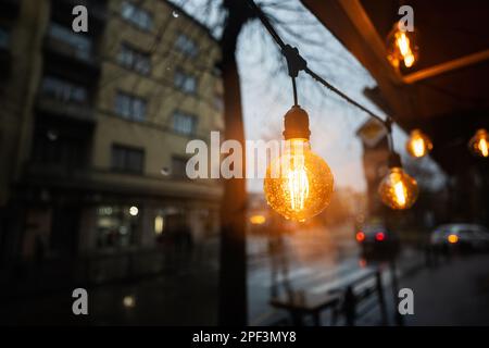 Glühbirnen Girlande in Rain City Street. Stockfoto