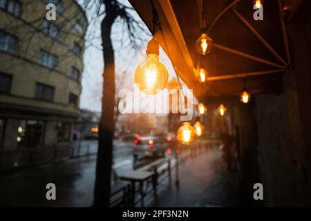 Glühbirnen Girlande in Rain City Street. Stockfoto