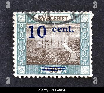 Stornierte Briefmarke, gedruckt von Deutschland, Saarland, die den Saarfluss in Mettlach zeigt, Aufschlag 10c auf 30pF, französische Besatzung, ca. 1921. Stockfoto