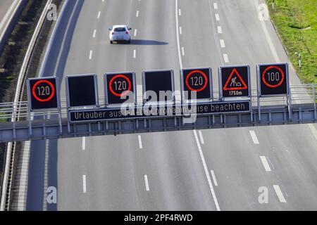 Rückkehrer aus dem Urlaub müssen Corona-Hinweise, Änderungsmitteilungen und Verkehrsschilder auf der Autobahn A8 in der Nähe von Stuttgart, Baden-Württemberg beachten Stockfoto