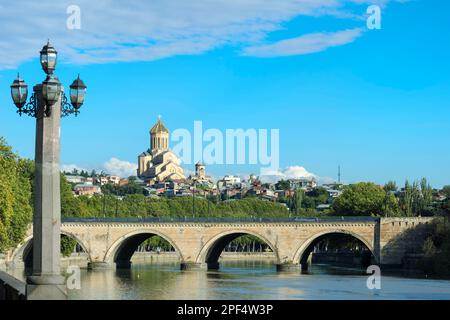 Chughureti oder Saarbrücken Brücke über den Fluss Mtkvari, Kathedrale der Heiligen Dreifaltigkeit auf dem Hügel, Tiflis Georgia, Kaukasus, Mittlerer Osten Stockfoto