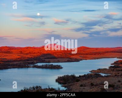 Sonnenuntergang bei Vollmond im Wichita Mountains National Wildlife Refuge in Oklahoma Stockfoto