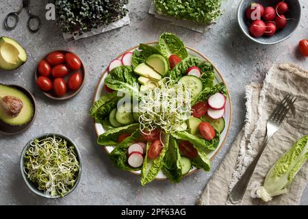 Gemüsesalat mit frischen Rettichsprossen, Tomaten und Avocado, mit hausgemachtem Brokkoli und Kohlmikrogreens Stockfoto