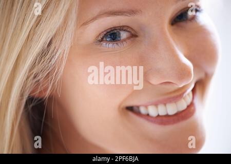 Was für ein erstaunliches Lächeln - tolle Zähne. Nahaufnahme einer schönen jungen Frau, die dich mit einem strahlenden Lächeln ansieht. Stockfoto