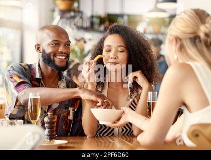 Delikatessen sollten immer geteilt werden. Eine Gruppe von Freunden, die sich eine Schüssel Pommes Frites teilen. Stockfoto