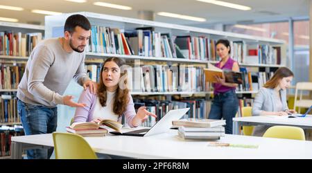 Schülerinnen und Schüler bereiten sich gemeinsam auf die Prüfung in der Bibliothek vor Stockfoto