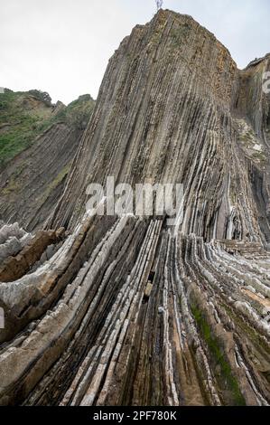 Blick auf steil geneigte Schichten von Flysch-geologischer Formation an der Atlantikküste bei Zumaia bei Ebbe, Baskenland, Spanien Stockfoto