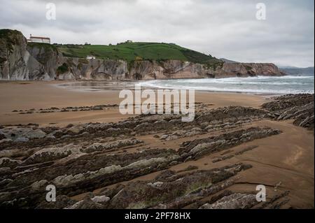 Blick auf steil geneigte Schichten von Flysch-geologischer Formation an der Atlantikküste bei Zumaia bei Ebbe, Baskenland, Spanien Stockfoto