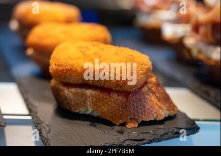 Typischer Mini-Burger-Snack aus dem Baskenland, Pinchos oder Pinxtos, kleines Stück Brot mit verschiedenen Belägen, serviert in der Bar in San-Sebastian oder Bilba Stockfoto