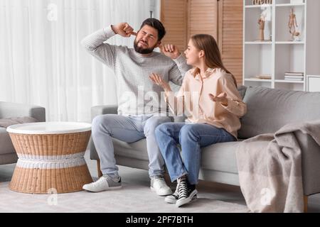 Ein junges Paar, das zu Hause unter lautem Lärm leidet Stockfoto