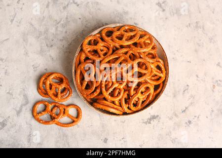 Schüssel mit leckeren Brezeln auf hellem Hintergrund Stockfoto