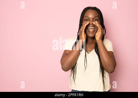 Positive Junge Schwarze Frau Mit Der Hand Nahe Dem Mund, Die Ankündigung Macht, Fröhliche Afroamerikanische Frau, Die Nachrichten Oder Informationen Teilt, Während Sie Isola Steht Stockfoto