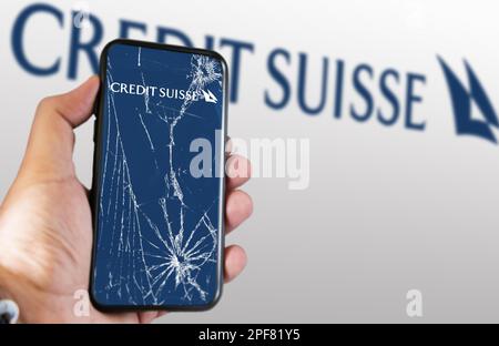 New York, USA, März 2023: Hand hält ein Telefon mit dem Credit Suisse Logo auf dem rissigen Bildschirm. Im März 2023 erlebte die Credit Suisse eine scharfe dro Stockfoto