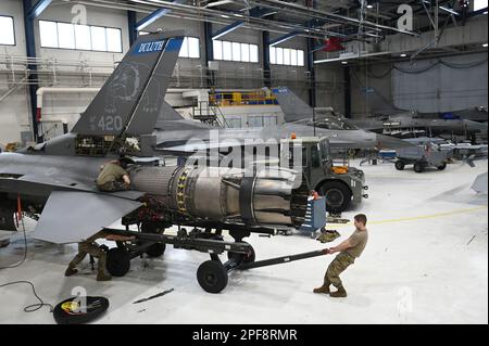 Duluth, Minnesota, USA. 28. Februar 2023. Spezialisten für Aerospace Propulsion System, die dem 148. Fighter Wing, Minnesota Air National Guard, zugeteilt sind, manövrieren einen 3000E-Anhänger unter dem F110-129 Turbofan-Flugzeugmotor auf einem F-16cm Fighting Falcon, 28. Februar 2023. Der Anhänger dient zur Unterstützung beim ein- und Ausbau des Motors beim F-16 und stellt sicher, dass kein Kontakt mit dem Motorraum besteht, was die Integrität der Düse oder des Motors gefährdet. Kredit: USA National Guard/ZUMA Press Wire Service/ZUMAPRESS.com/Alamy Live News Stockfoto