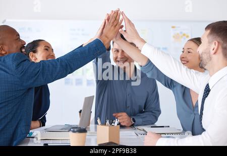 Vielfältige Gruppe von lächelnden Geschäftsleuten, die einen Erfolg feiern und sich gegenseitig ein High Five geben. Ein Team glücklicher Profis, das einen Erfolg feiert Stockfoto