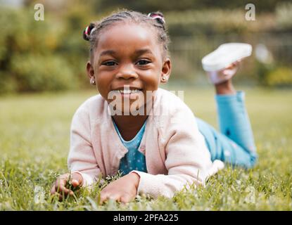 Spielzeit ist die beste Zeit. Ein kleines Mädchen, das gern Zeit allein in ihrem Familiengarten verbringt. Stockfoto