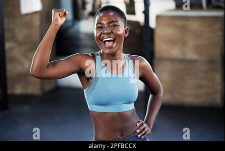 Stärke im Inneren, Stolz im ganzen Körper. Eine fitte junge Frau, die sich frei bewegt, während sie allein im Fitnessstudio steht. Stockfoto