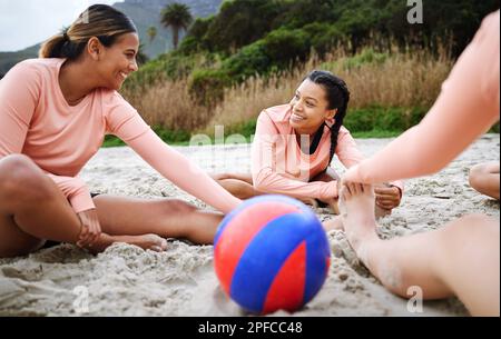 Volleyball, Stretching und Frauen mit Ball am Strand, bereit für Spiel, Wettkampf und Sport. Teamwork, Fitness und weibliche Spieler dehnen sich weiter Stockfoto