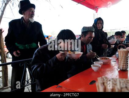 Ein kleines Straßenrestaurant, das Lagman-Nudeln und Reis mit Teigtaschen auf einem wöchentlichen Viehmarkt in den Außenbezirken von Kashgar, Xinjiang, China, serviert. Stockfoto