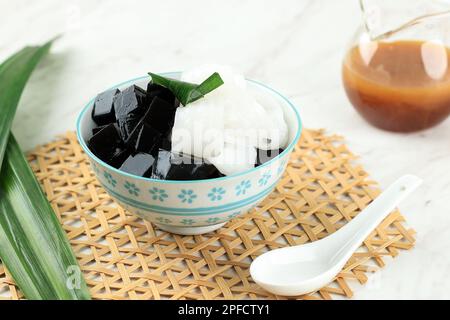 Schwarze Kräuter, Grasgelee mit Kokosnussfleisch, serviert mit Palmenzuckersirup Stockfoto