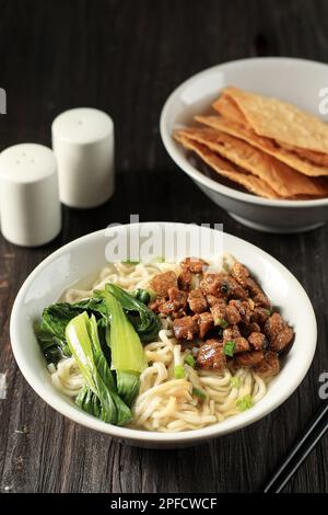 Mie Ayam, beliebtes indonesisches Street Food mit Nudeln, Hühnchen und grünem Gemüse mit köstlicher Brühe und Frühlingszwiebeln Stockfoto