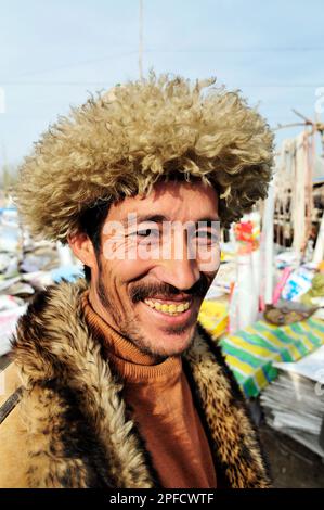 Porträt eines uigurischen Mannes mit Winterjacke. Foto auf einem Wochenmarkt in den Außenbezirken von Kashgar, Xinjiang, China. Stockfoto